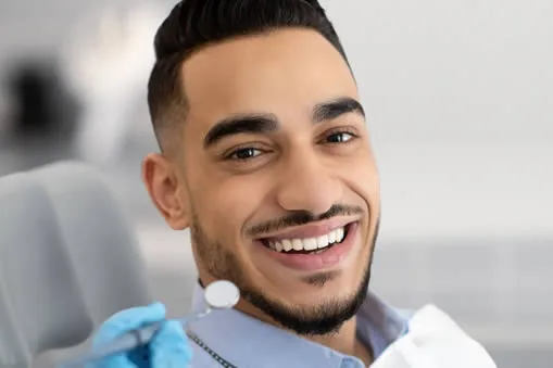 Patient smiling in dental chair after bonding procedure