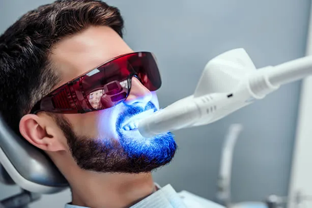man receiving teeth whitening in dental office